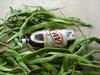 runner beans next to a 2 liter bottle